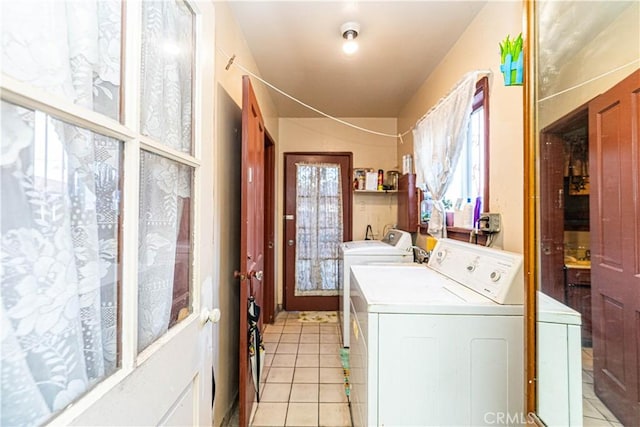 laundry room with laundry area, independent washer and dryer, and light tile patterned flooring