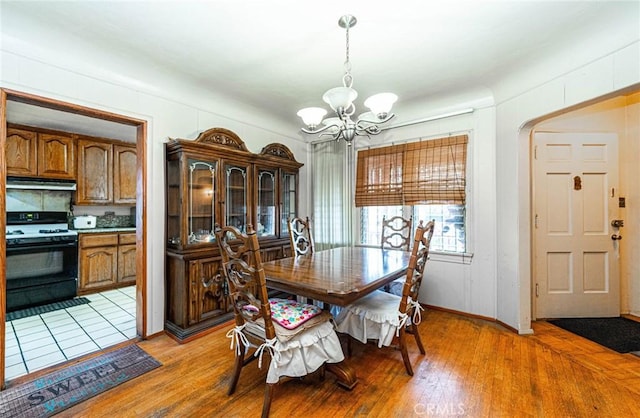 dining space with a chandelier and light wood-style floors