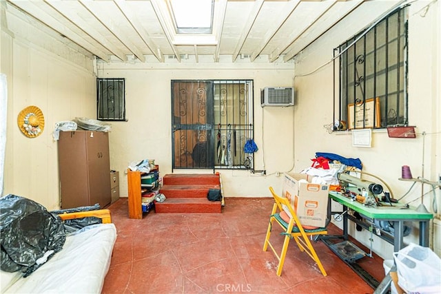 recreation room with a wall mounted AC, a skylight, and tile patterned floors