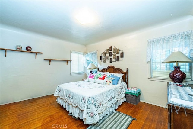 bedroom featuring dark wood-style floors and multiple windows