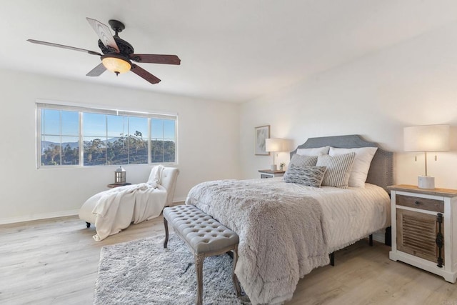 bedroom with light wood finished floors, ceiling fan, and baseboards