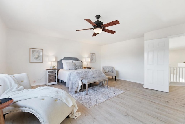 bedroom featuring ceiling fan, light wood-type flooring, and baseboards