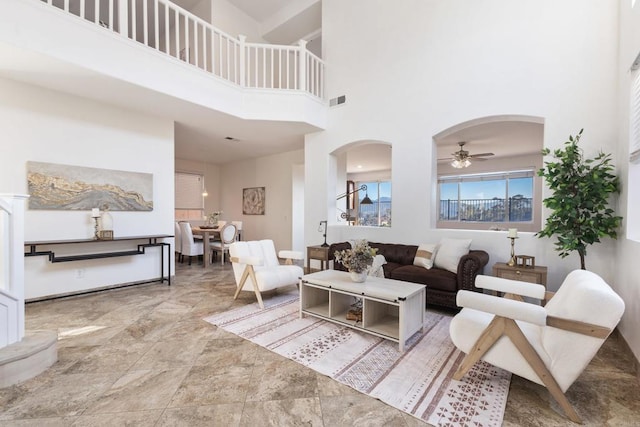 living area featuring a towering ceiling and arched walkways