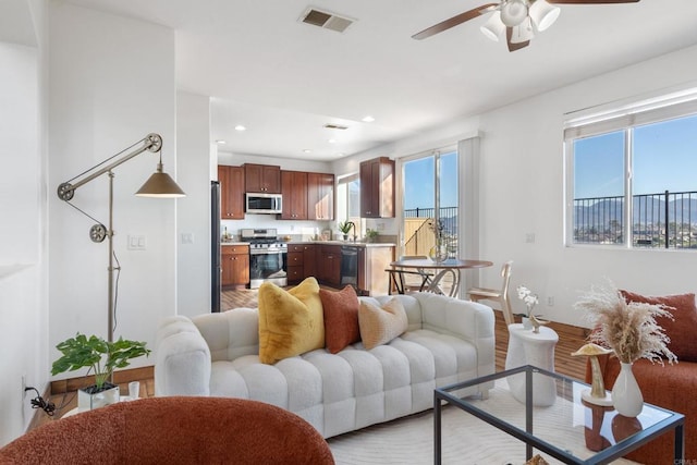 living area with a ceiling fan, recessed lighting, a healthy amount of sunlight, and visible vents