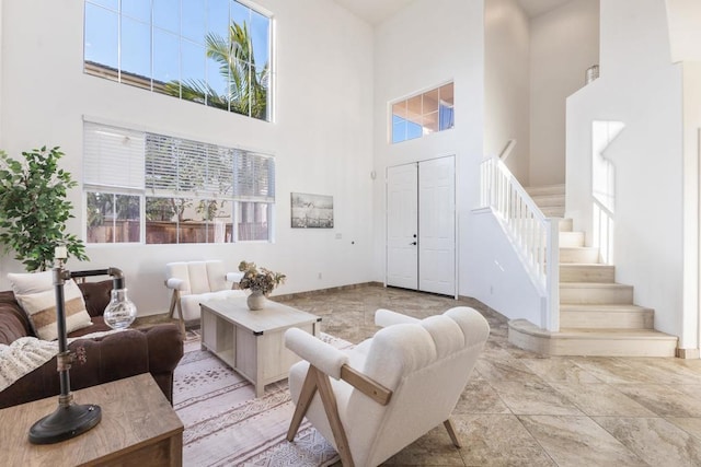 living room featuring a high ceiling and stairway