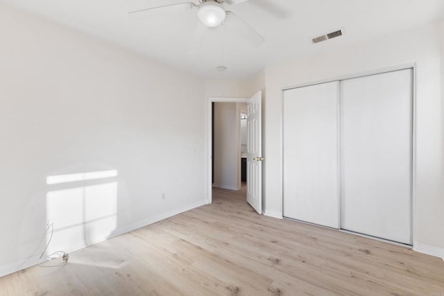 unfurnished bedroom with light wood finished floors, a closet, visible vents, ceiling fan, and baseboards