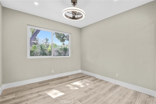 unfurnished room with light wood-style flooring, baseboards, and recessed lighting