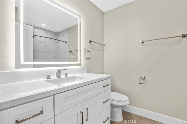 full bath featuring toilet, a marble finish shower, vanity, and baseboards