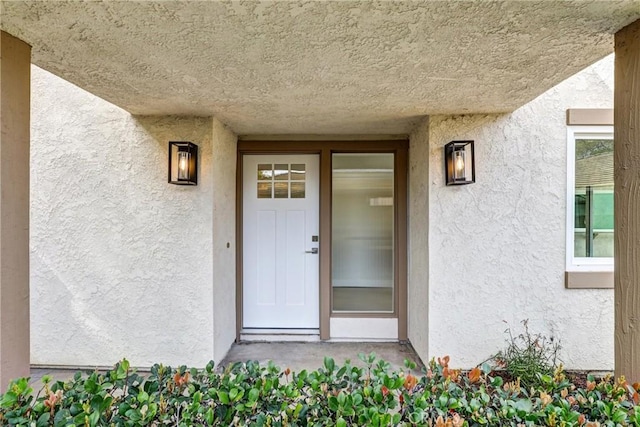 view of exterior entry featuring stucco siding