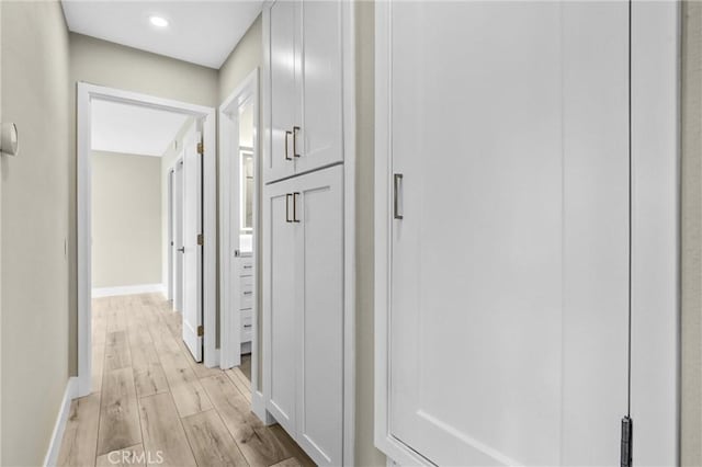 hall featuring light wood finished floors and baseboards