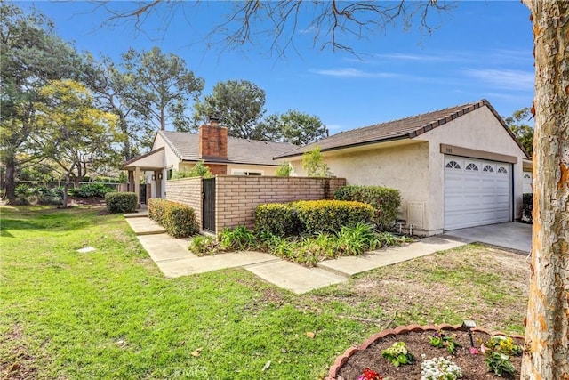 view of side of property featuring a garage, a chimney, fence, a yard, and stucco siding