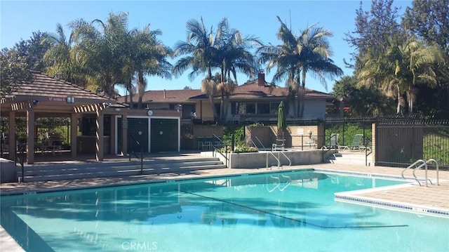 community pool featuring a gazebo, a patio, and fence