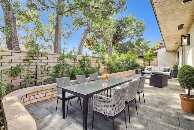 view of patio / terrace featuring an outdoor hangout area, outdoor dining space, and a fenced backyard