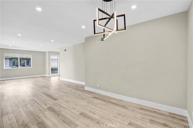 unfurnished living room featuring light wood finished floors, visible vents, and baseboards