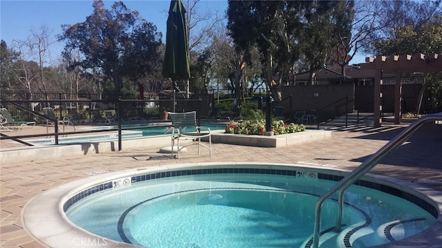 view of swimming pool featuring a community hot tub, a patio area, fence, and a pergola