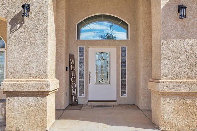 doorway to property featuring stucco siding