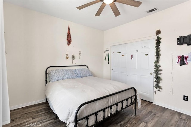 bedroom featuring ceiling fan, dark wood-type flooring, visible vents, and baseboards