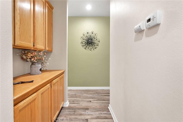 hallway with light wood finished floors and baseboards