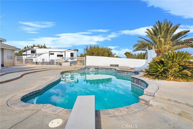 view of pool with fence private yard, a fenced in pool, a diving board, and a water slide