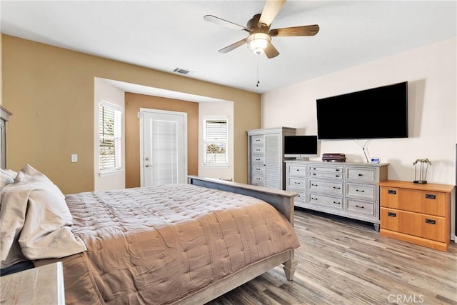 bedroom with ceiling fan, visible vents, and light wood-style floors