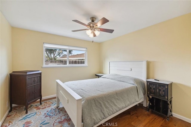 bedroom with a ceiling fan, baseboards, and wood finished floors