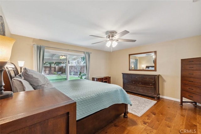 bedroom featuring access to exterior, ceiling fan, baseboards, and wood finished floors