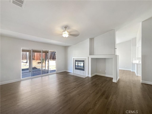 unfurnished living room featuring ceiling fan, dark wood-type flooring, a fireplace, visible vents, and baseboards