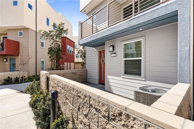 view of side of home featuring cooling unit and a balcony