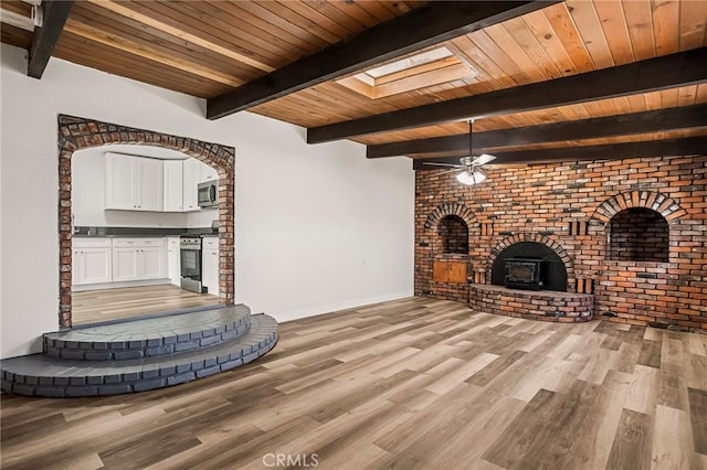 355 French St, Willows, CA 95988 - unfurnished living room with light wood-style floors, a wood stove, wooden ceiling, and beam ceiling