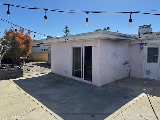 back of property with a patio area, fence, and stucco siding