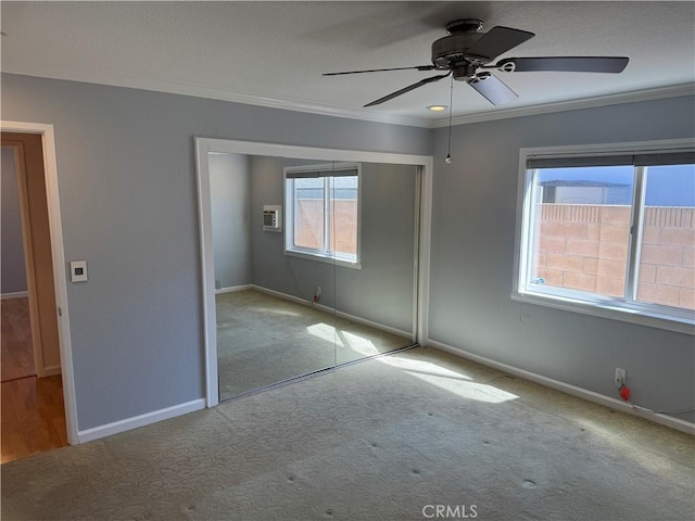 unfurnished bedroom with carpet, crown molding, baseboards, and a closet