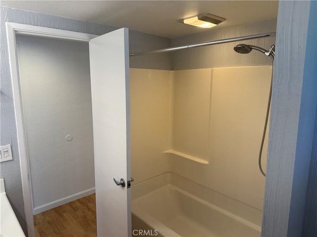 full bath with wood finished floors, shower / tub combination, and baseboards