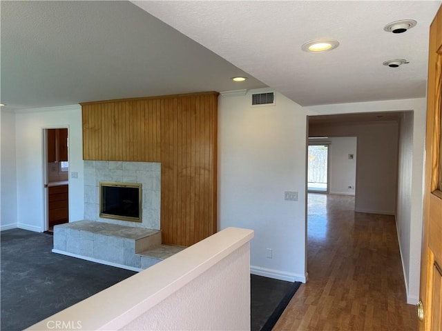 hall with dark wood finished floors, recessed lighting, visible vents, ornamental molding, and baseboards