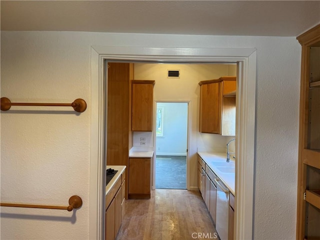 kitchen featuring a sink, visible vents, light countertops, brown cabinets, and dishwasher