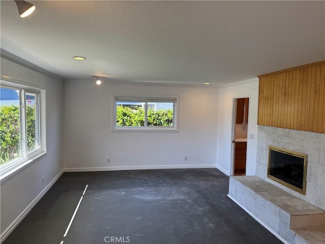 unfurnished living room with concrete floors, baseboards, a wealth of natural light, and a tile fireplace