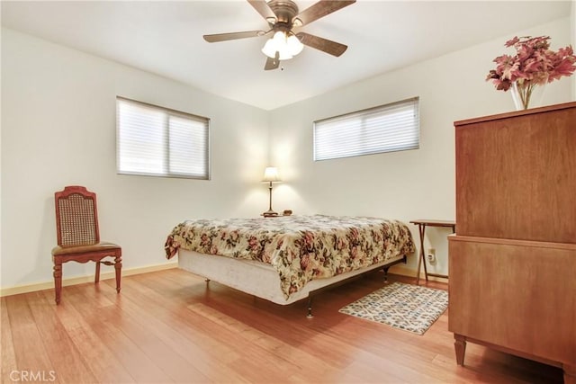 bedroom featuring ceiling fan, baseboards, and wood finished floors