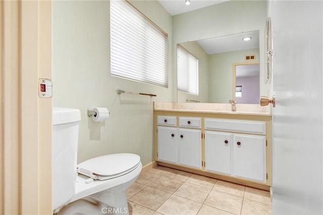 bathroom featuring visible vents, baseboards, toilet, tile patterned flooring, and vanity