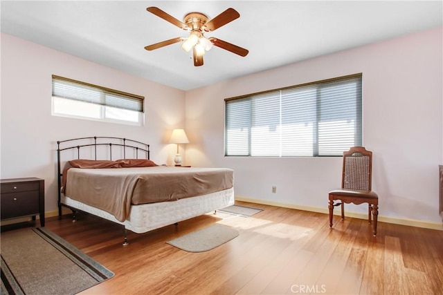 bedroom featuring wood finished floors, a ceiling fan, and baseboards