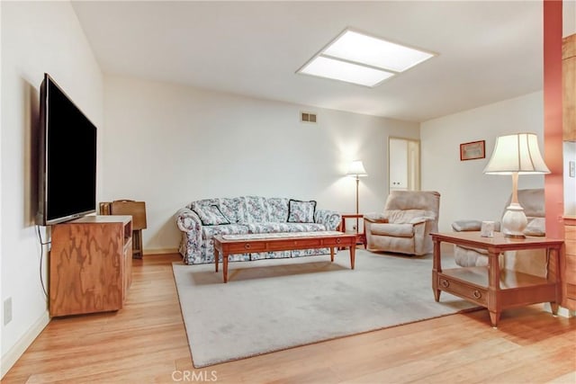 living area with light wood-style flooring and visible vents