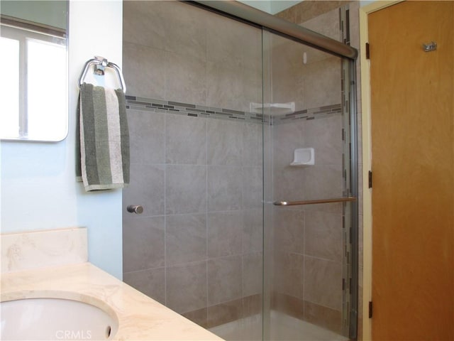 full bath with a tile shower and vanity