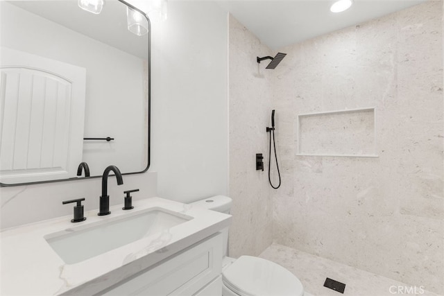 bathroom with toilet, a stall shower, and vanity