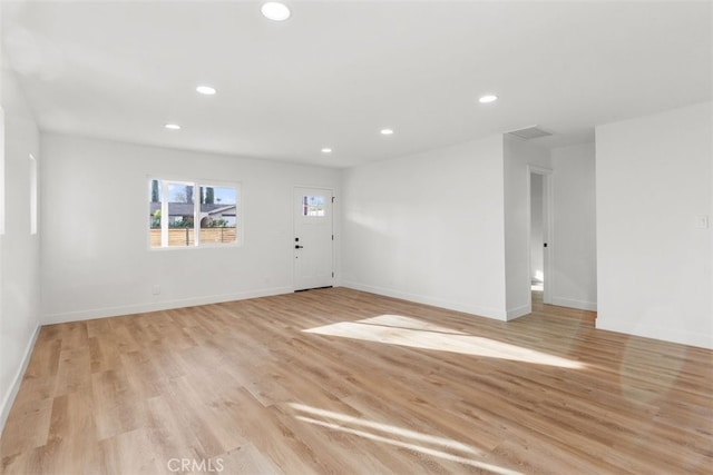 empty room with baseboards, light wood finished floors, visible vents, and recessed lighting