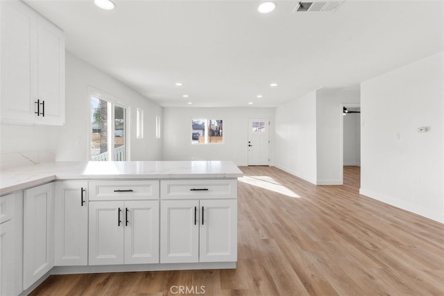 kitchen featuring visible vents, light wood-style flooring, open floor plan, white cabinetry, and recessed lighting