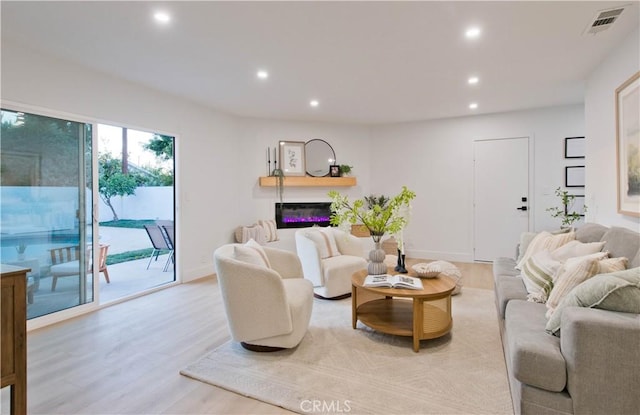 living area with light wood-type flooring, baseboards, visible vents, and recessed lighting