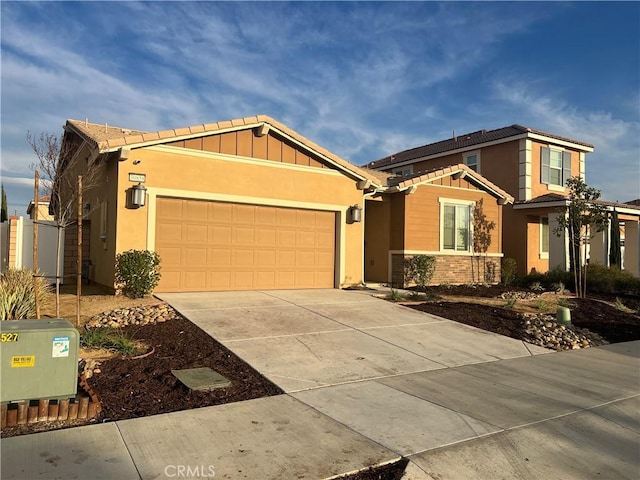 view of front of property featuring a garage, driveway, board and batten siding, and stucco siding