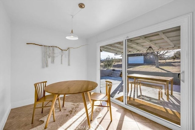 tiled dining room featuring baseboards