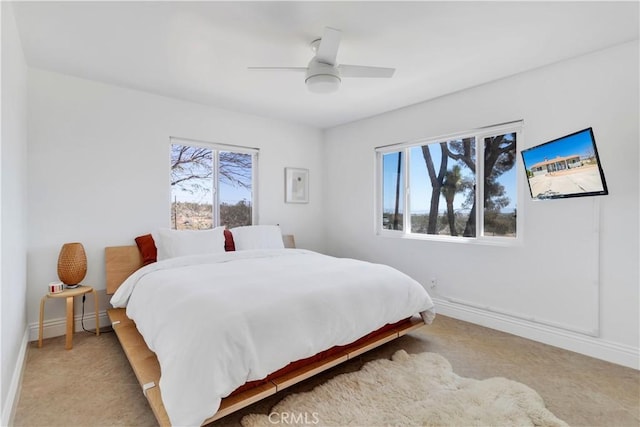 bedroom with light carpet, a ceiling fan, and baseboards