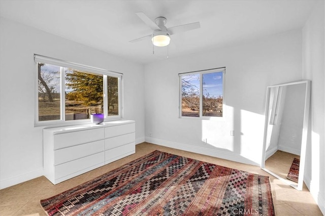 interior space with a ceiling fan and baseboards