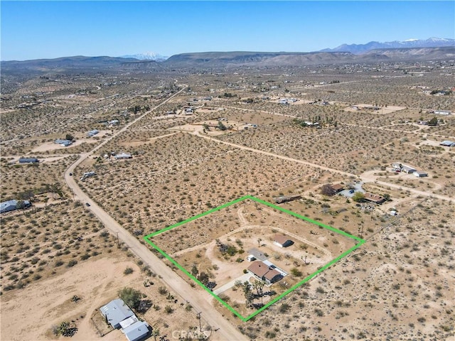 aerial view featuring a desert view and a mountain view