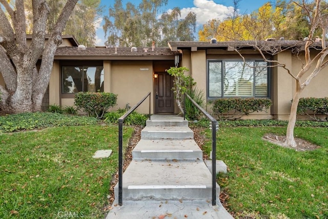 view of front of property featuring a front lawn and stucco siding